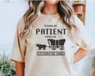 Please be patient I'm from the 1900s funny tshirt.  The picture is Oregon Trail themed with an animal pulled a cart.  Shirt color is ivory and design is almost black