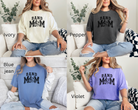 band mom tshirt is colors ivory, pepper, blue jean, and violet.