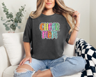 Cheer mom shirt in the color pepper with a bright doodle style font with a backgroung behind the words that appears like black and white dalmatian dots.