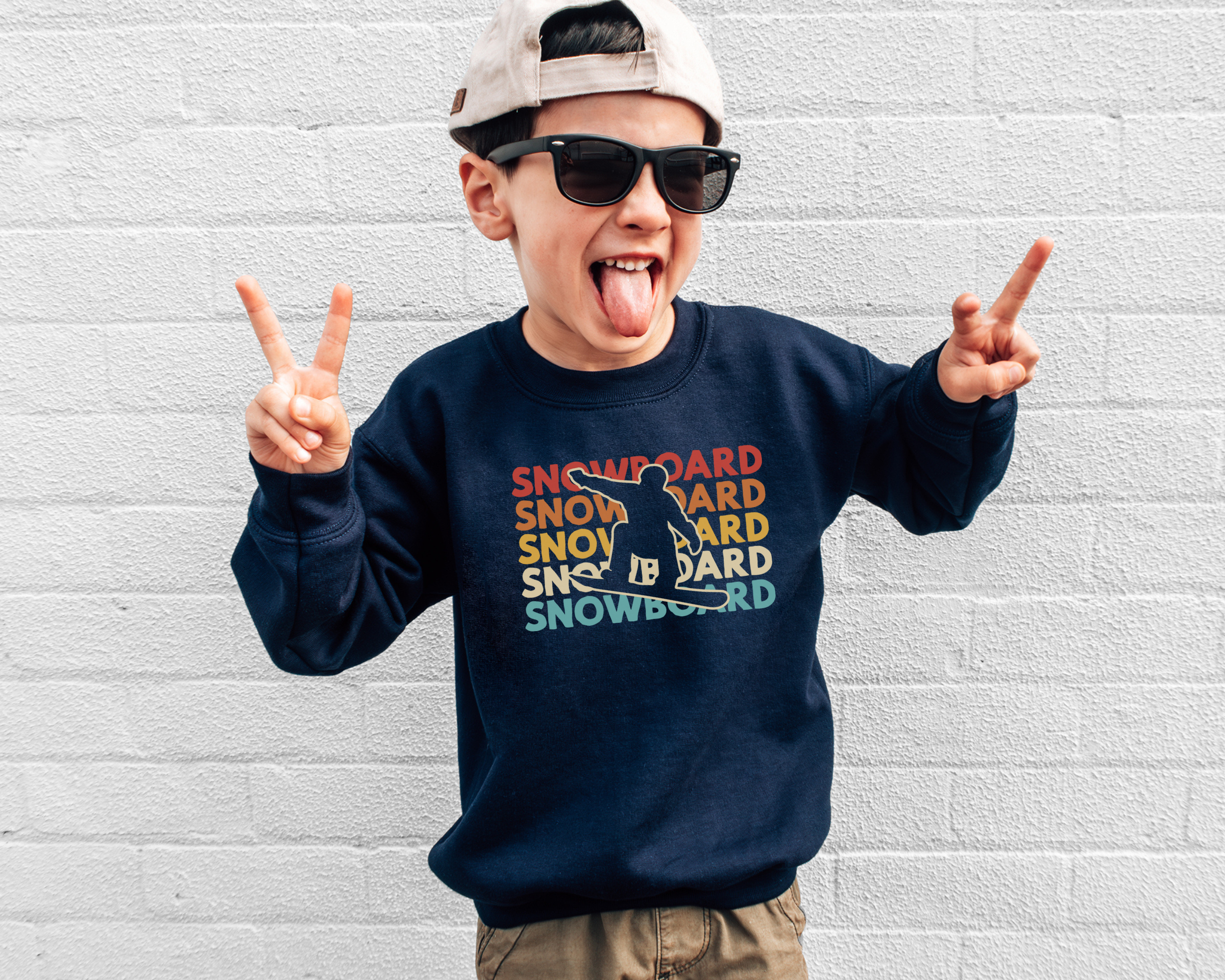 kids snowboarding sweatshrit that says snowboard stacked in 5 rows in red orange yellow tan and light blue.  In the middle of the stacked words there is a cut out of a snowboarder.  This sweatshirt is navy