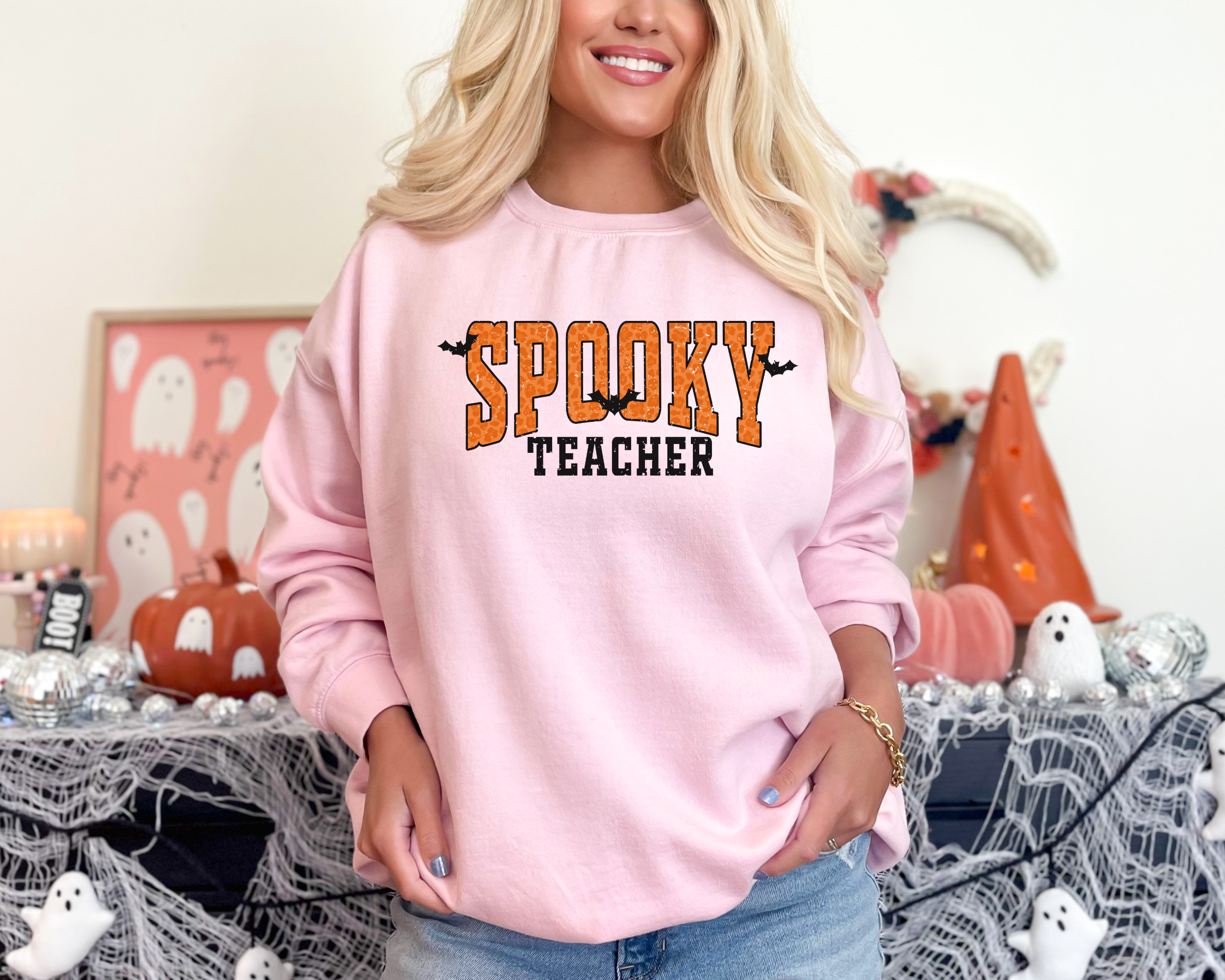 Orange Spooky teacher design on a crewneck sweatshirt in the color pink